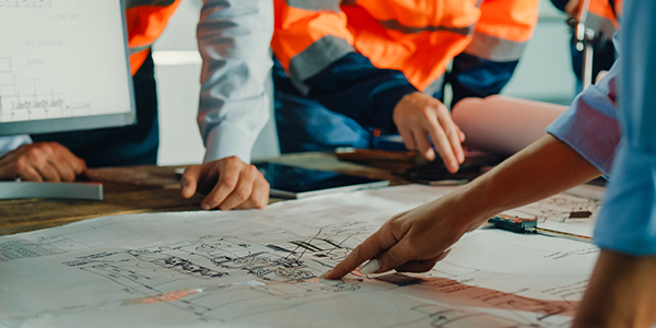 Worker are discussing on the  blueprint for a industrial projects.
