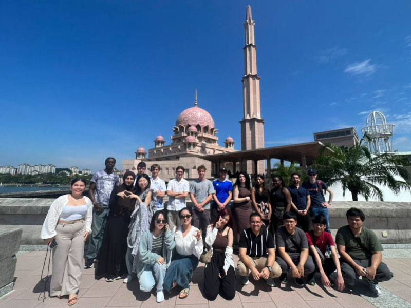 International students on campus tour taking a group photo as part of induction week activities.