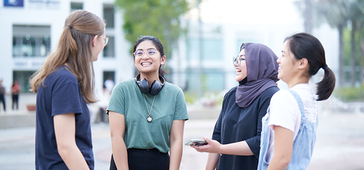 Student of UNM semenyih standing outdoors and engaged in a lively conversation.