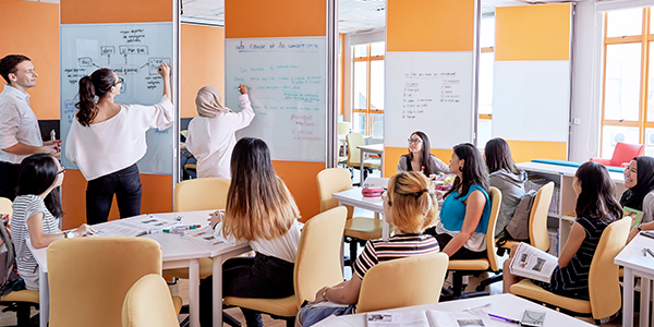 The atmosphere is collaborative and dynamic, with students working together on a project.