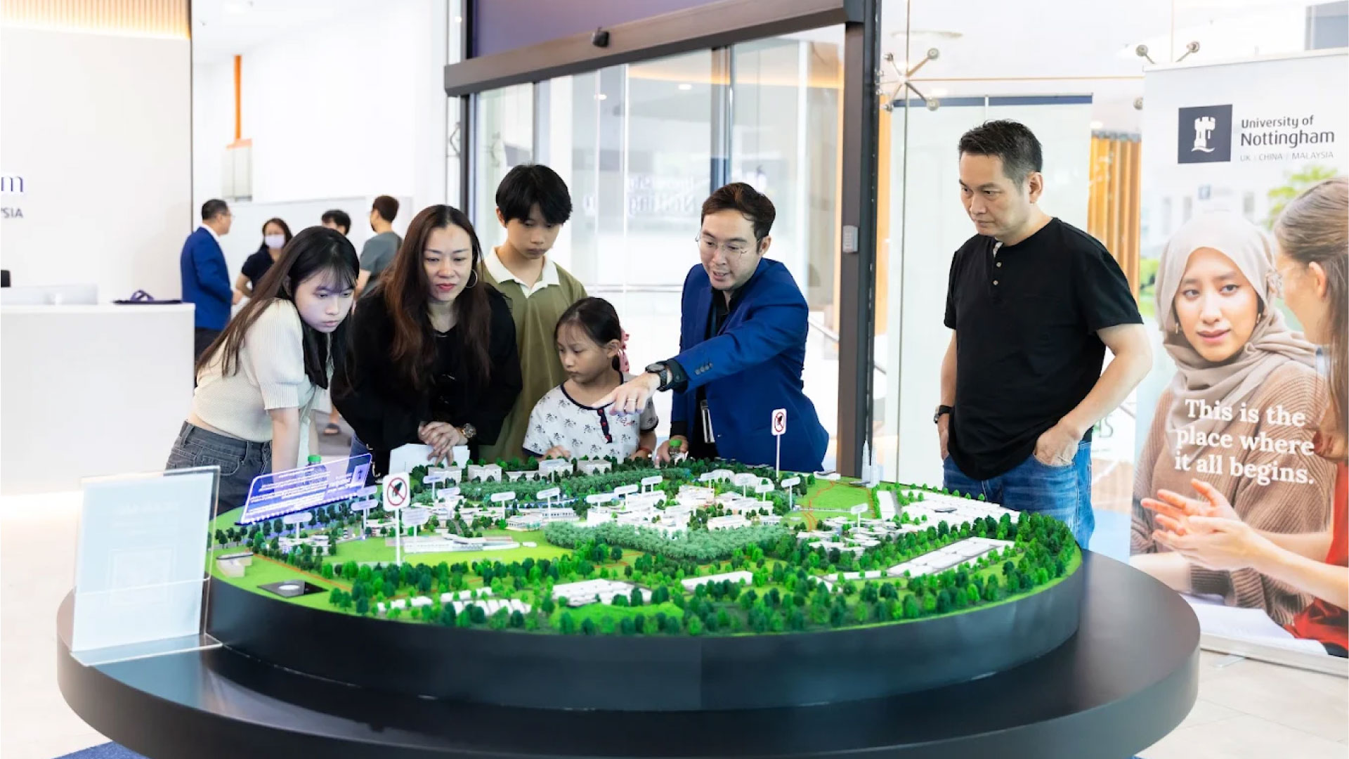 University of Nottingham Malaysia staff showing a campus model to prospective students and parents